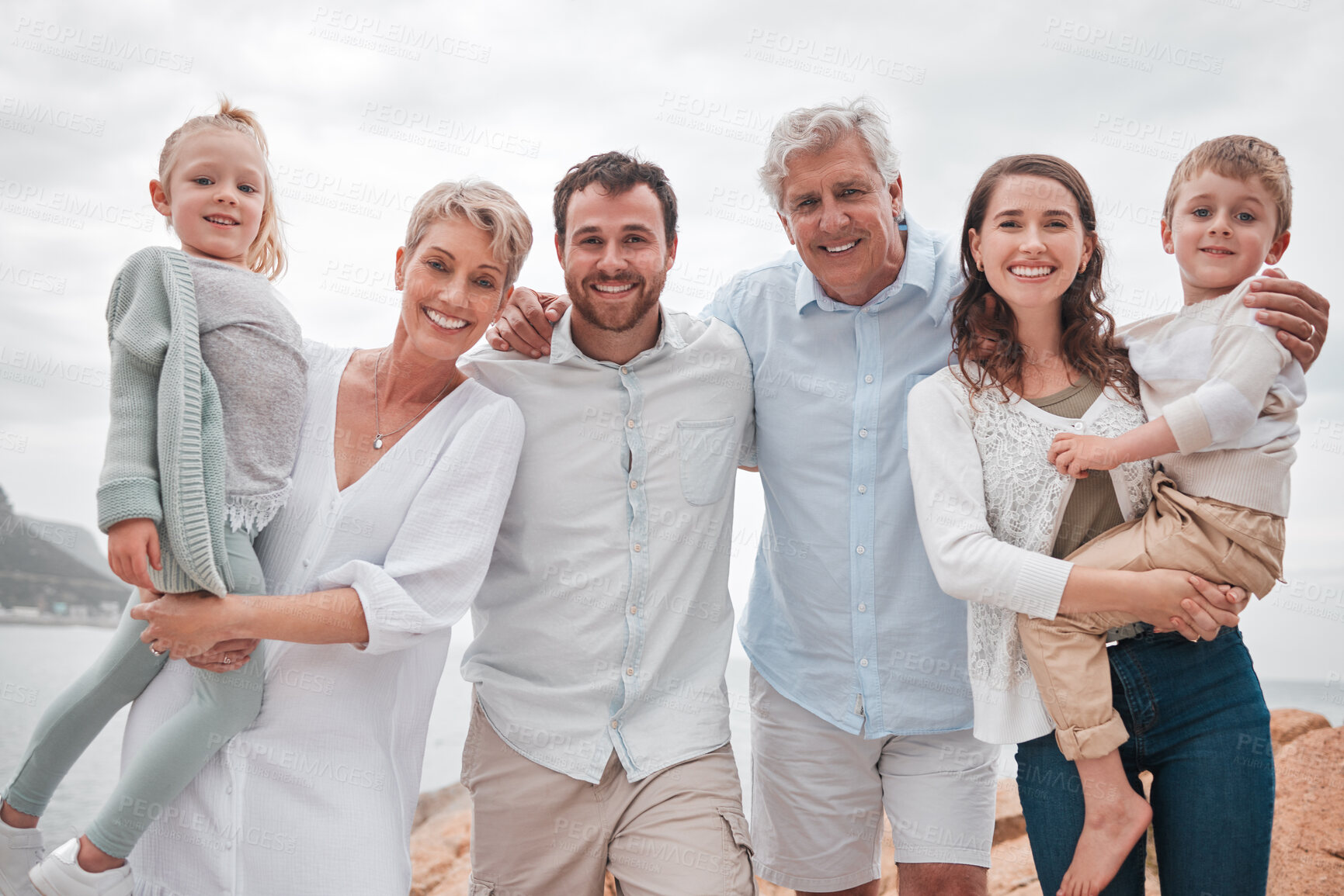 Buy stock photo Family, portrait and happy for bonding, travel and vacation together in Santorini with ocean view. People, love and adventure outdoor for relationship, holiday or retirement on mountain with smile