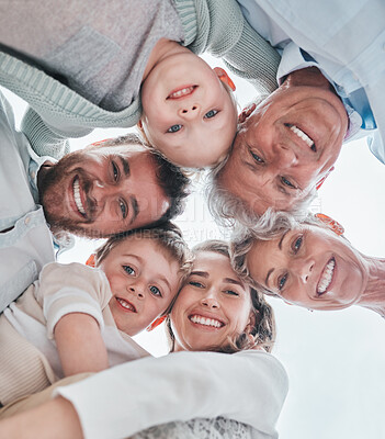 Buy stock photo Low angle shot of a happy family huddled together
