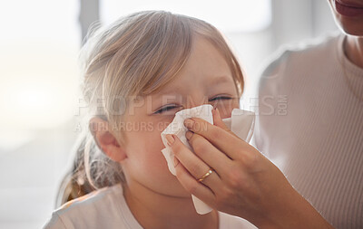 Buy stock photo Shot of a mother wiping her little girl’s nose with a tissue in bed at home