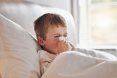 Buy stock photo Shot of a little boy feeling ill in bed at home and blowing his nose