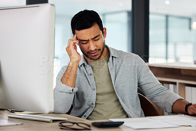 Buy stock photo Shot of a young businessman experiencing a headache at work