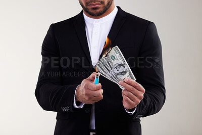 Buy stock photo Studio shot of an unrecognisable businessman burning a banknote against a white background