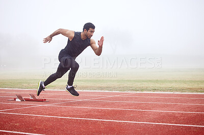 Buy stock photo Full length shot of a handsome young male athlete running on an outdoor track