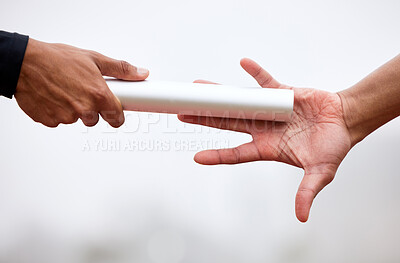 Buy stock photo Cropped shot of an unrecognizable male athlete grabbing a baton from his teammate during a relay race