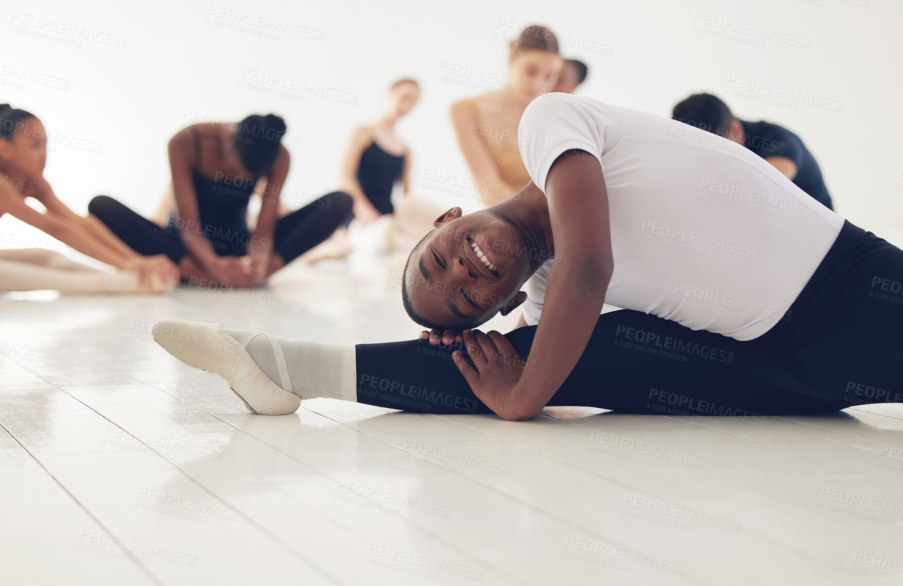 Buy stock photo Shot of a group of ballerinas warming up before practicing their routine