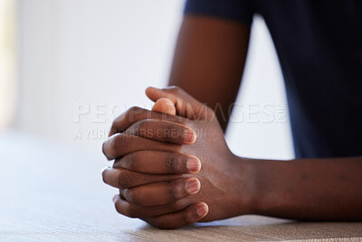 Buy stock photo Studio shot of an unrecognisable man sitting at a table with his hands clasped