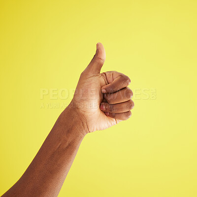 Buy stock photo Studio shot of an unrecognisable man showing thumbs up against a yellow background