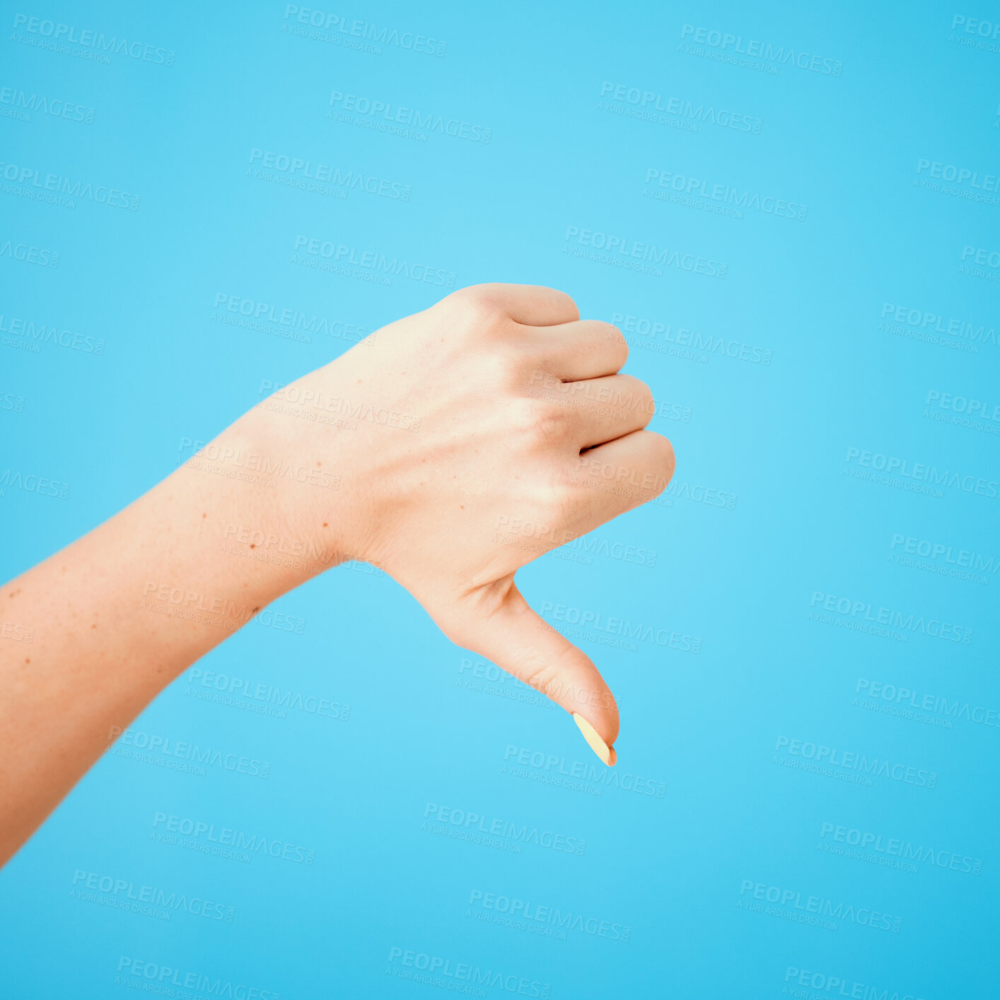 Buy stock photo Studio, vote and hand of woman with thumbs down for bad review, feedback and decision on blue background. Female person, rejection and finger with emoji for fake news, disagreement or negative rating