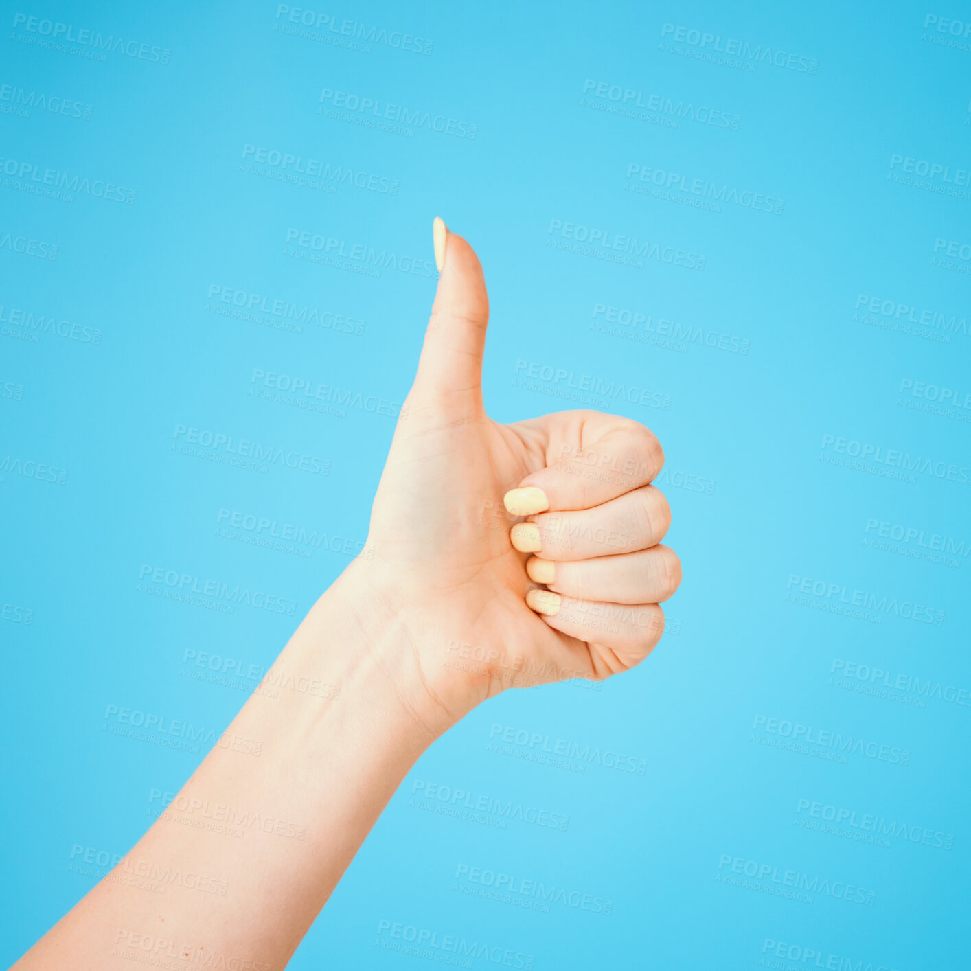 Buy stock photo Thumbs up, hand and woman in studio with sign language for positivity, agreement or acceptance. Emoji, satisfaction and female kindergarten teacher with approval gesture for career by blue background