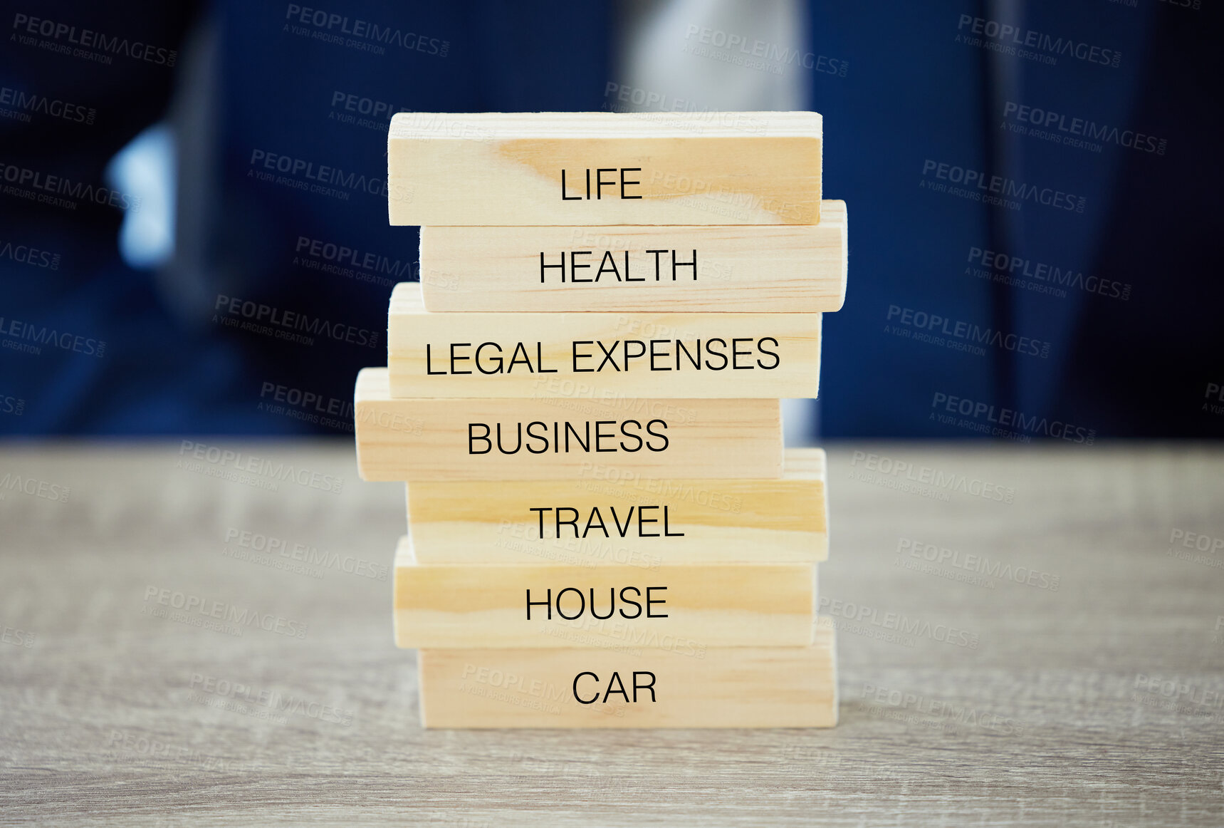 Buy stock photo Shot of an unrecognisable businessman assembling wooden blocks with insurance related words on them