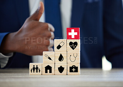 Buy stock photo Hands, building blocks and symbol for insurance in office with thumbs up for assets, health or life. Person, agent and wood toys with yes, property and icon for risk cover for real estate at company