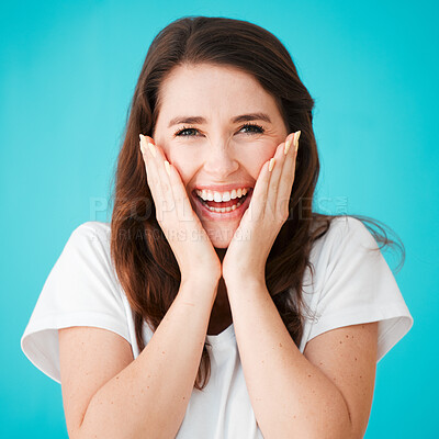 Buy stock photo Studio portrait of an attractive young woman looking surprised against a blue background