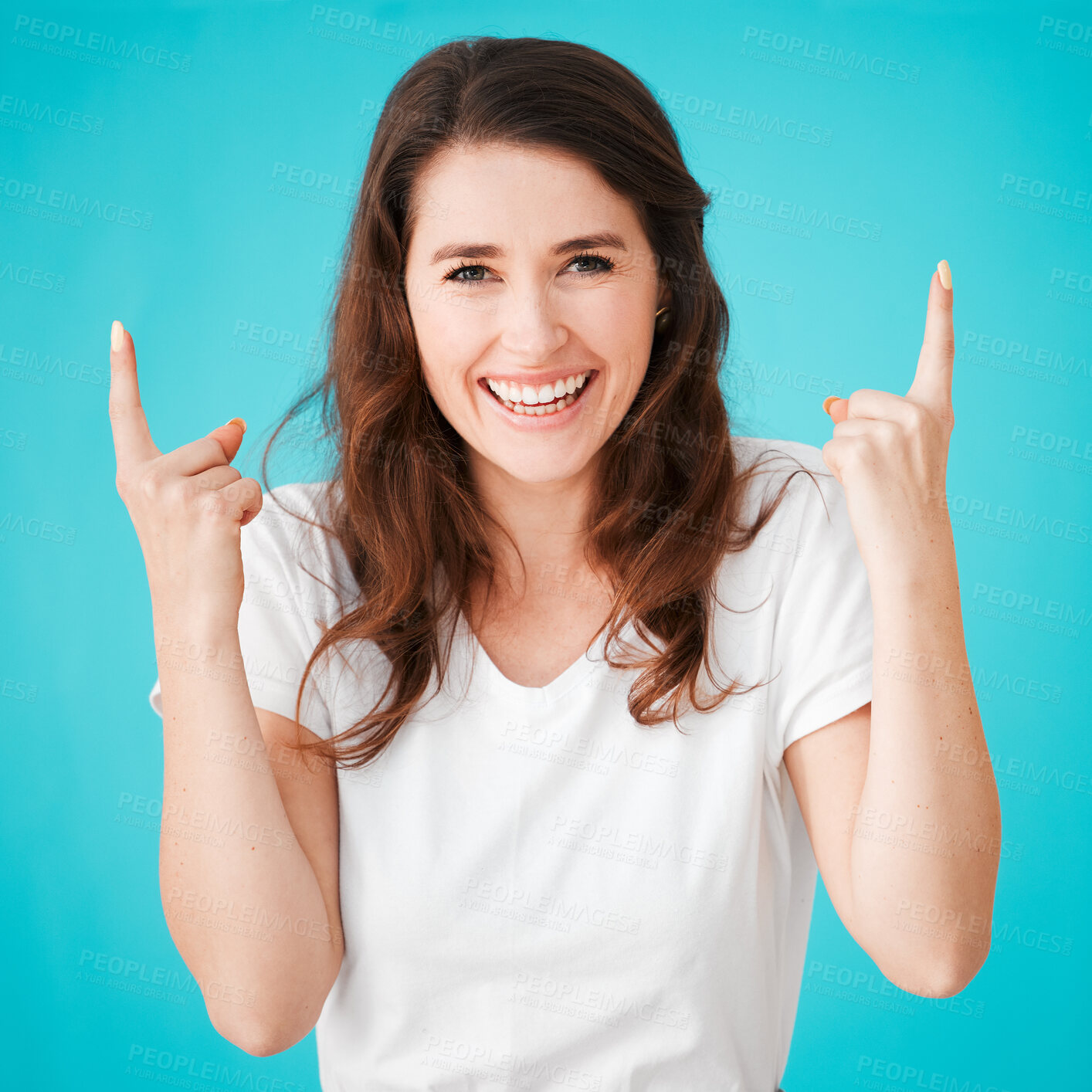 Buy stock photo Portrait, happy woman and pointing up in studio for advertising, presentation or show info. Face, laugh and model with hand gesture for promo, discount deal or sales offer isolated on blue background