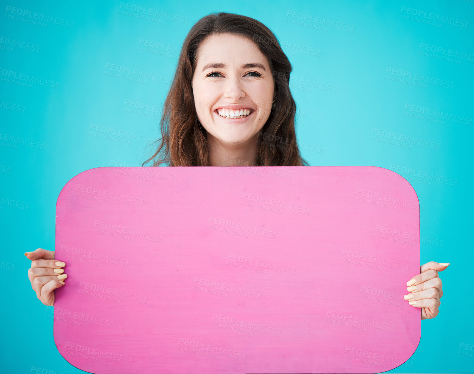 Buy stock photo Studio portrait of an attractive young woman holding up a blank sign against a blue background