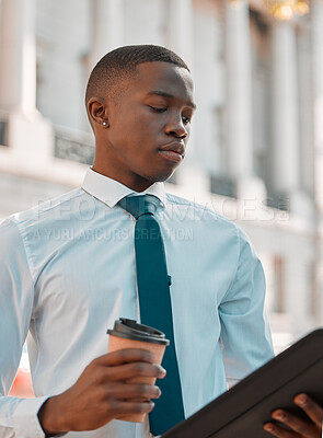 Buy stock photo Shot of a young male lawyer going through notes in the city