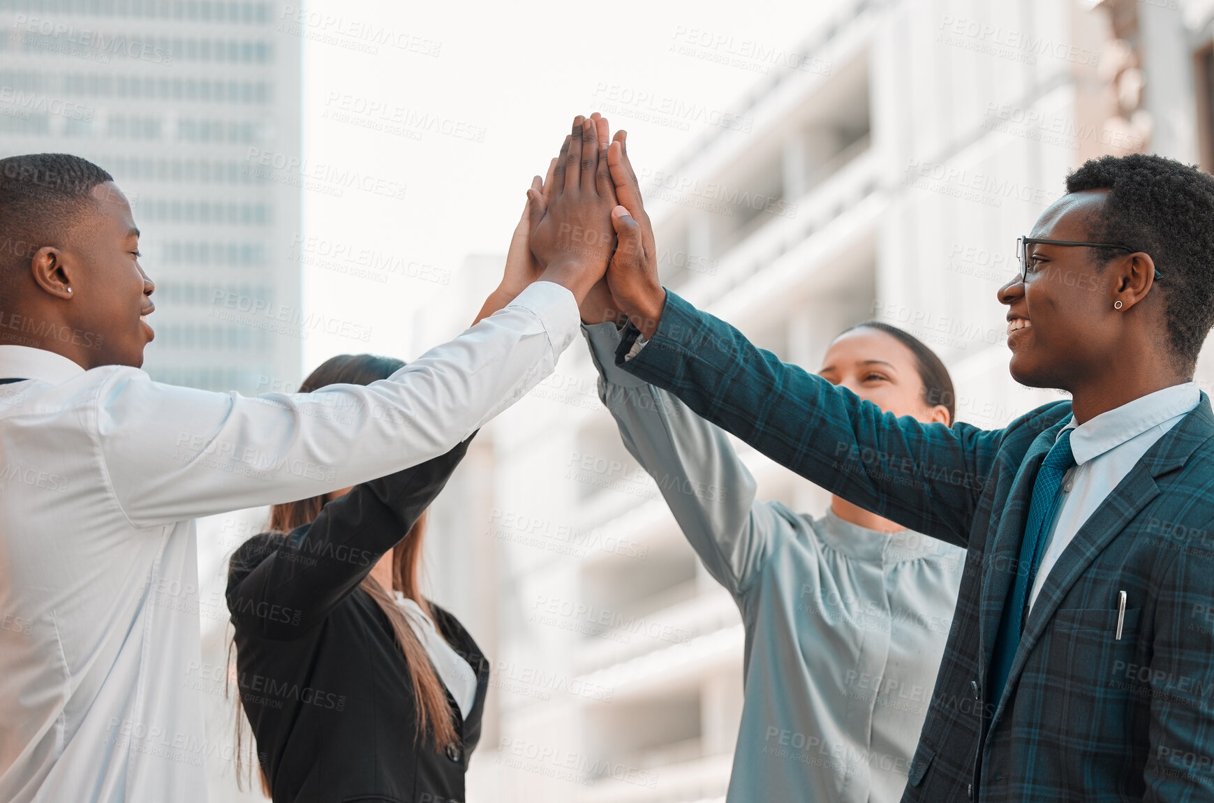 Buy stock photo Shot of a group of businesspeople giving each other a high five in the city