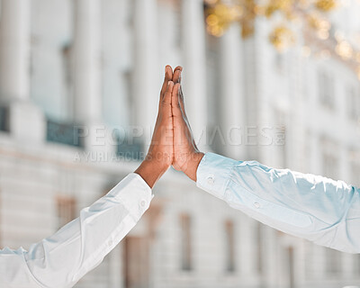Buy stock photo Shot of two unrecognizable people giving each other a high five in the city