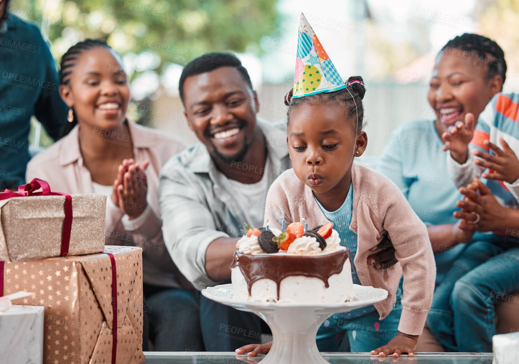 Buy stock photo Shot of a little girl celebrating her birthday with her family at home