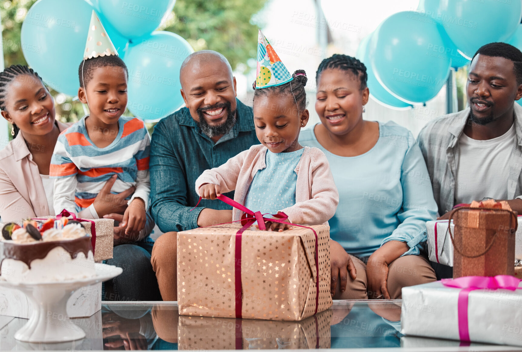 Buy stock photo Big family, celebration and excited child with birthday gift, happiness and cheerful as community in home. African people, kid and opening box at party with grandparents, gathering or event in lounge