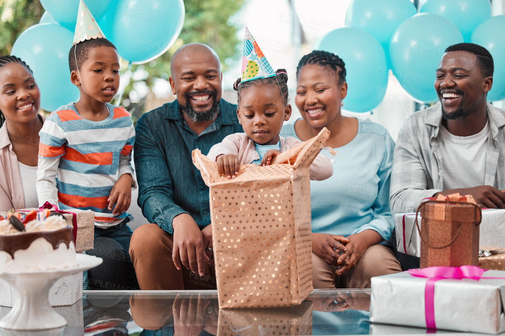 Buy stock photo Big family, child and gift at birthday party with grandparents, gathering or event in lounge. African people, celebration and excited kid with opening box, happiness and cheerful as community in home