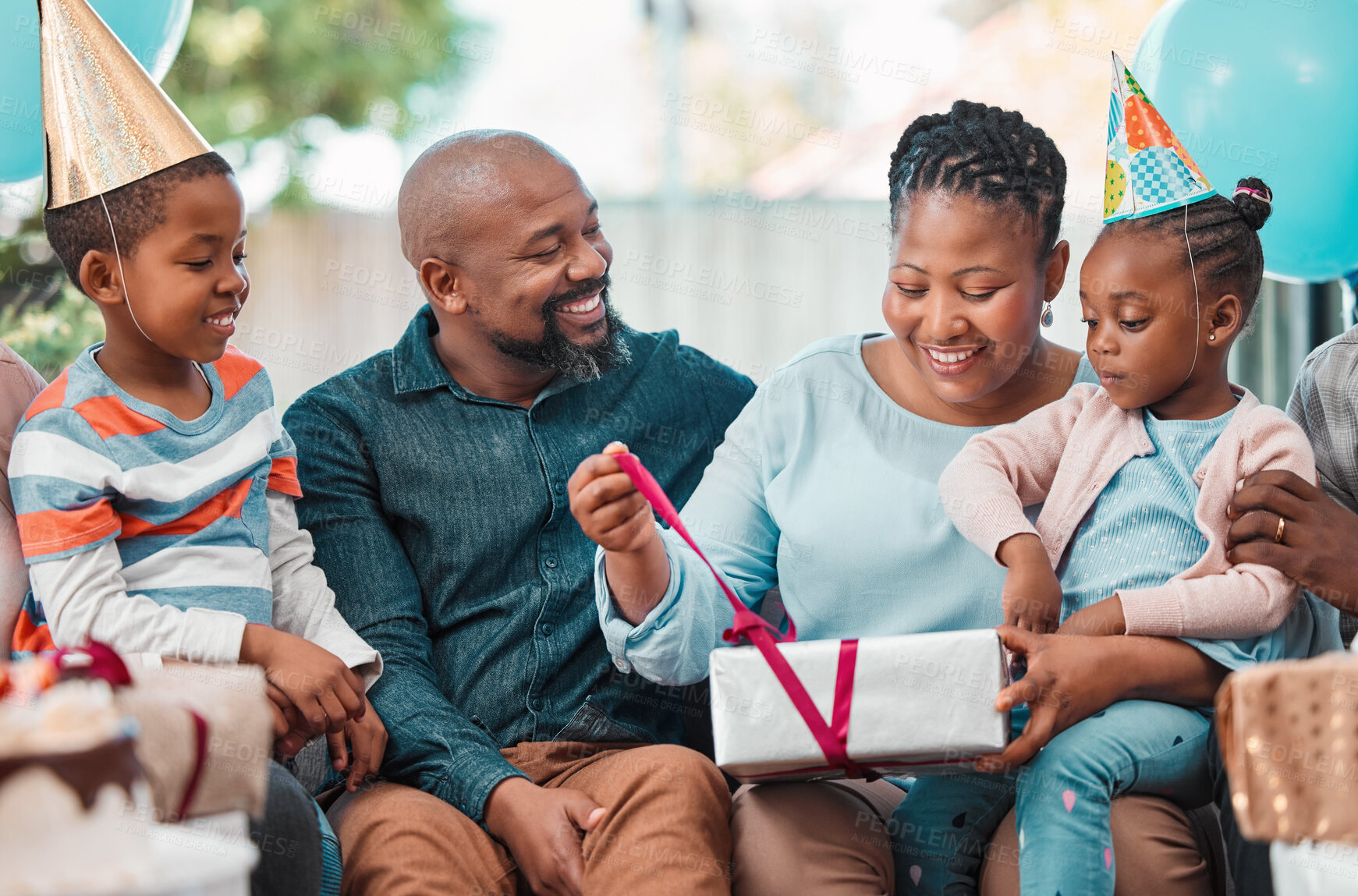 Buy stock photo Black family, celebration and excited woman with birthday gift, happiness and cheerful as community in home. African people, kid and opening box at party with parents, gathering and event in lounge