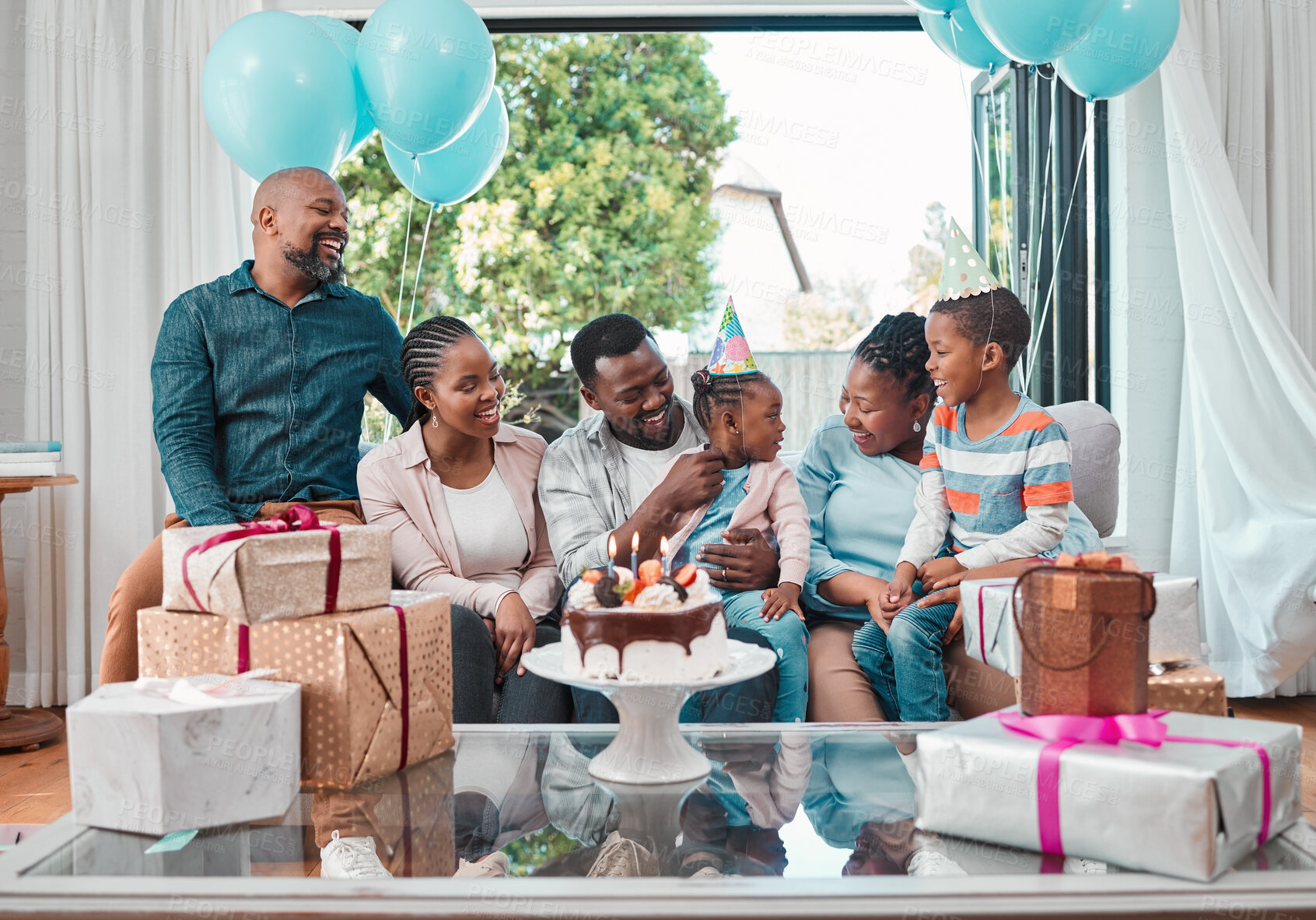 Buy stock photo Birthday cake, gifts and black child with family at party with balloons for celebration at home. Happy, presents and African girl with dessert for special event with grandparents, parents and brother
