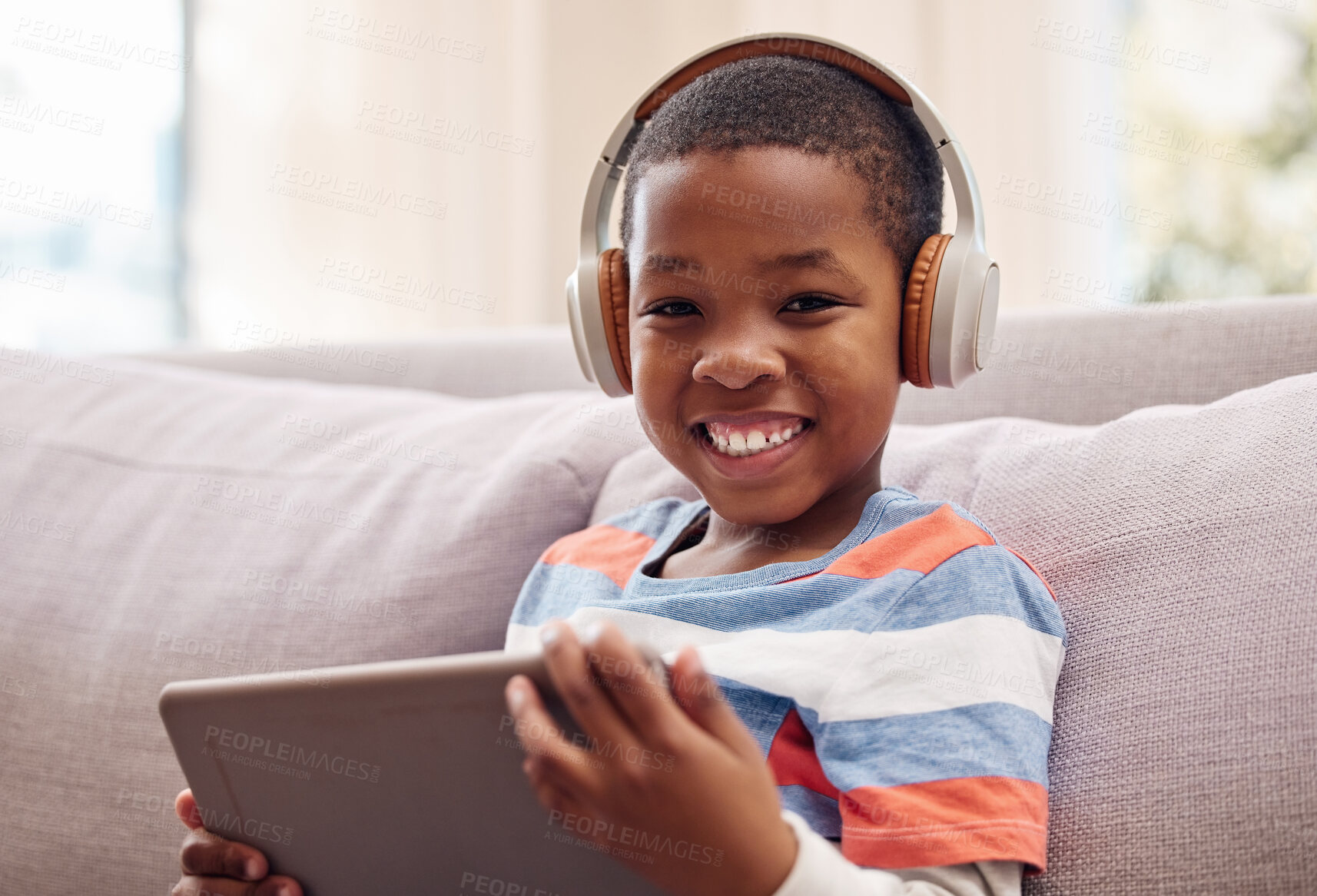 Buy stock photo Portrait, tablet and happy African kid with headphones for learning, education or listening to music. Face, boy and child with technology for streaming radio, relax and playing game on sofa in home