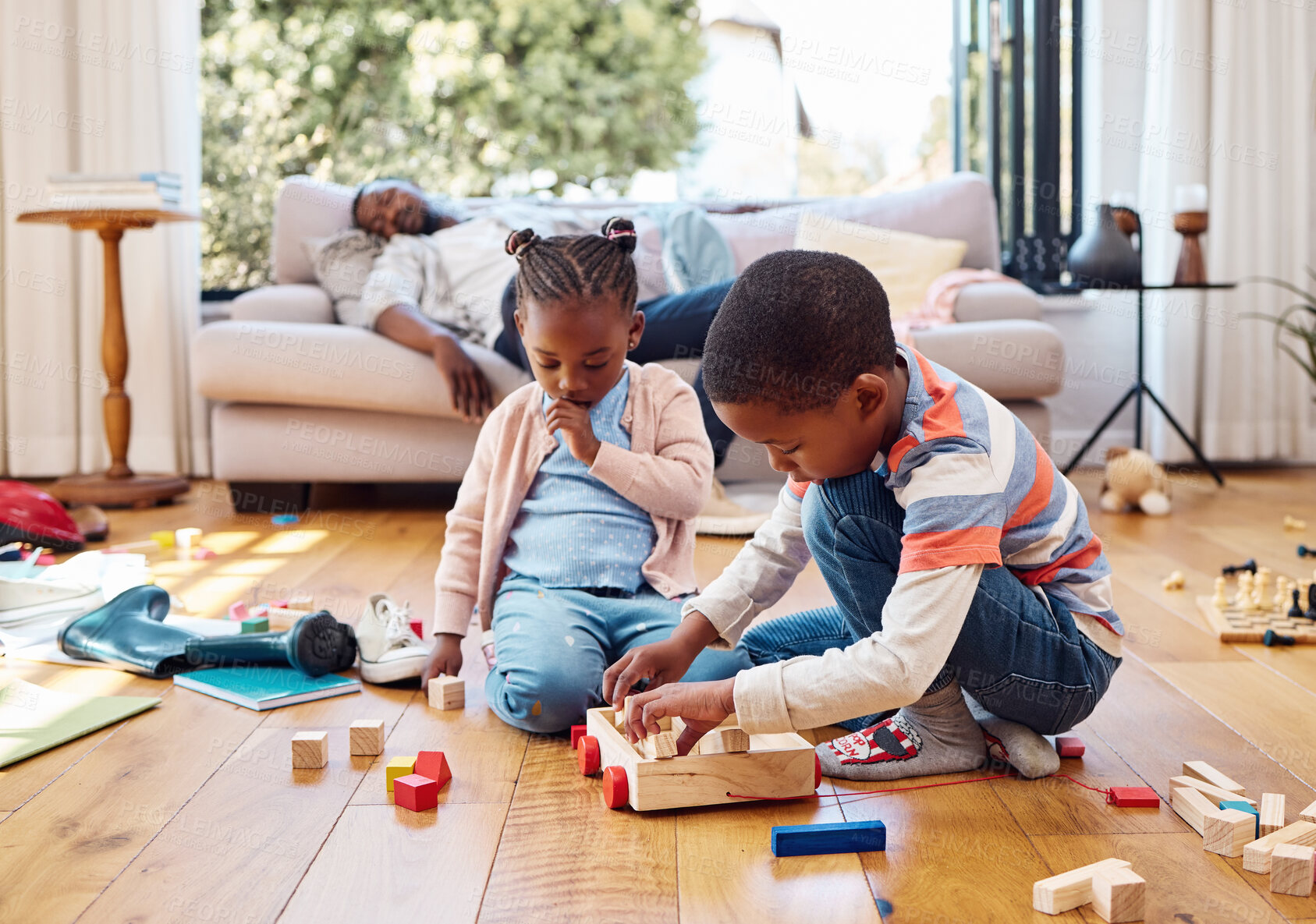 Buy stock photo Children, playing and toys on floor for development, relationship growth or tired dad on sofa. ADHD kids, messy or keeping busy in home for bonding, learning or creative with building blocks for game