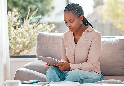 Buy stock photo Shot of a young woman relaxing at home using a digital tablet
