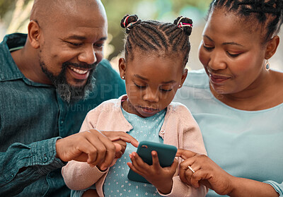 Buy stock photo Shot of a little girl using a phone with her grandparents at home