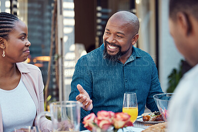 Buy stock photo Black family, lunch and people with conversation by home for love, event and eating together at reunion. African man, happy and communication in backyard at table for meal, nutrition and celebration