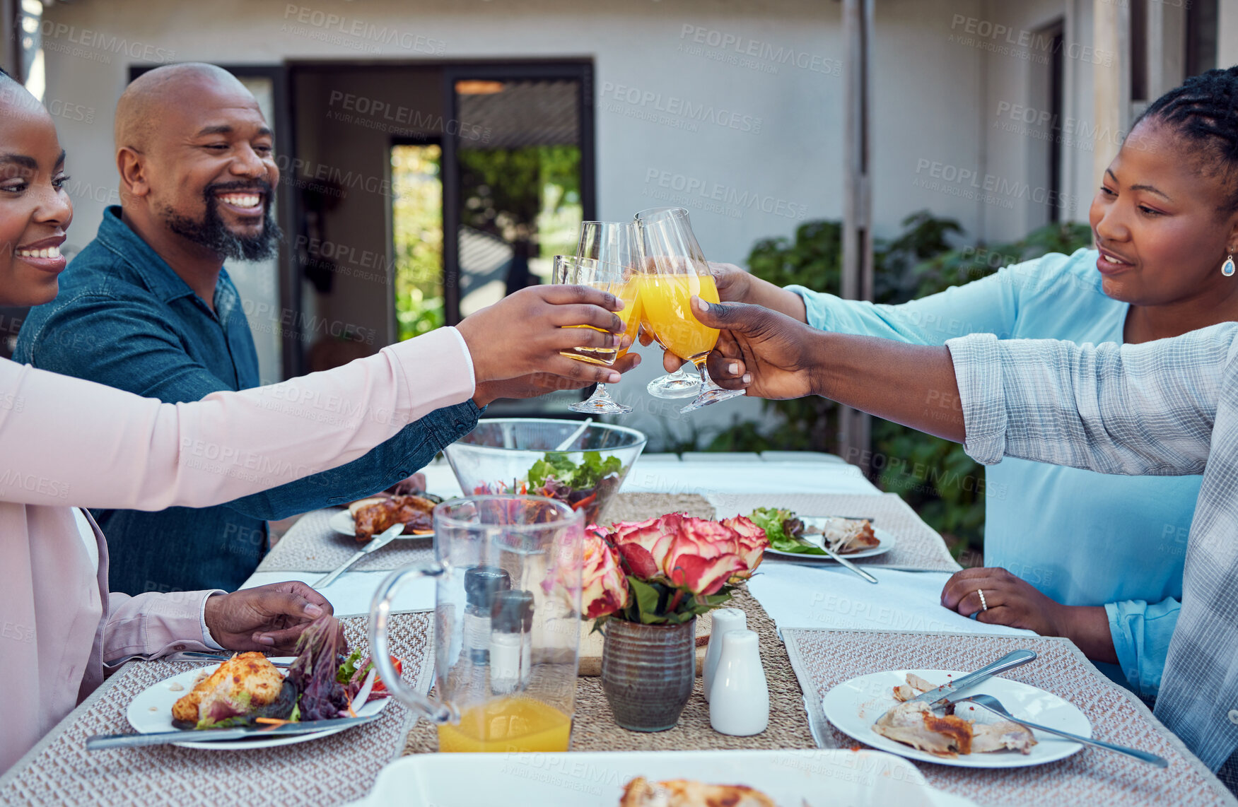 Buy stock photo Black family, toast and drinks at lunch with smile, connection and solidarity with cheers on patio. People, men and women with celebration, juice and glasses at party, backyard or thanksgiving in USA