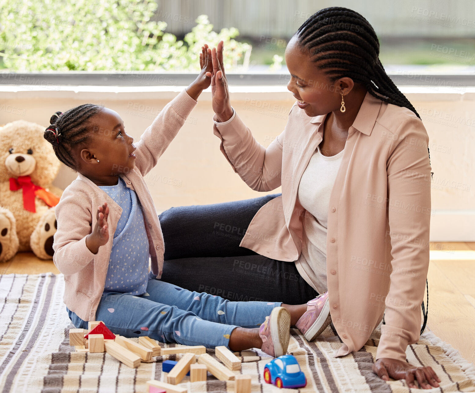Buy stock photo Shot of a little girl giving her mother a high five while playing at home