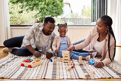 Buy stock photo Shot of a little girl playing with blocks with her parents at home