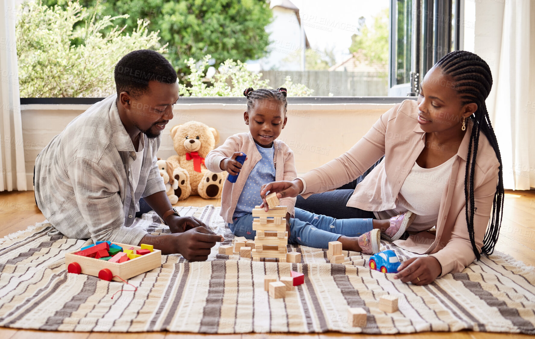 Buy stock photo African parents, bonding and building blocks with girl learning from family on floor of living room. Kid, growth and toys for child development with father and mother teaching daughter in home lounge