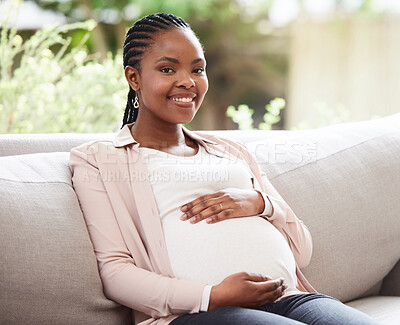 Buy stock photo Cropped portrait of an attractive young mother to be sitting on the sofa at home