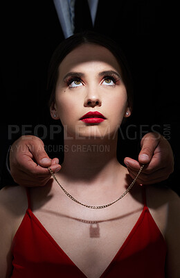 Buy stock photo Shot of an attractive young woman sitting in the studio while her boyfriend puts a necklace on her