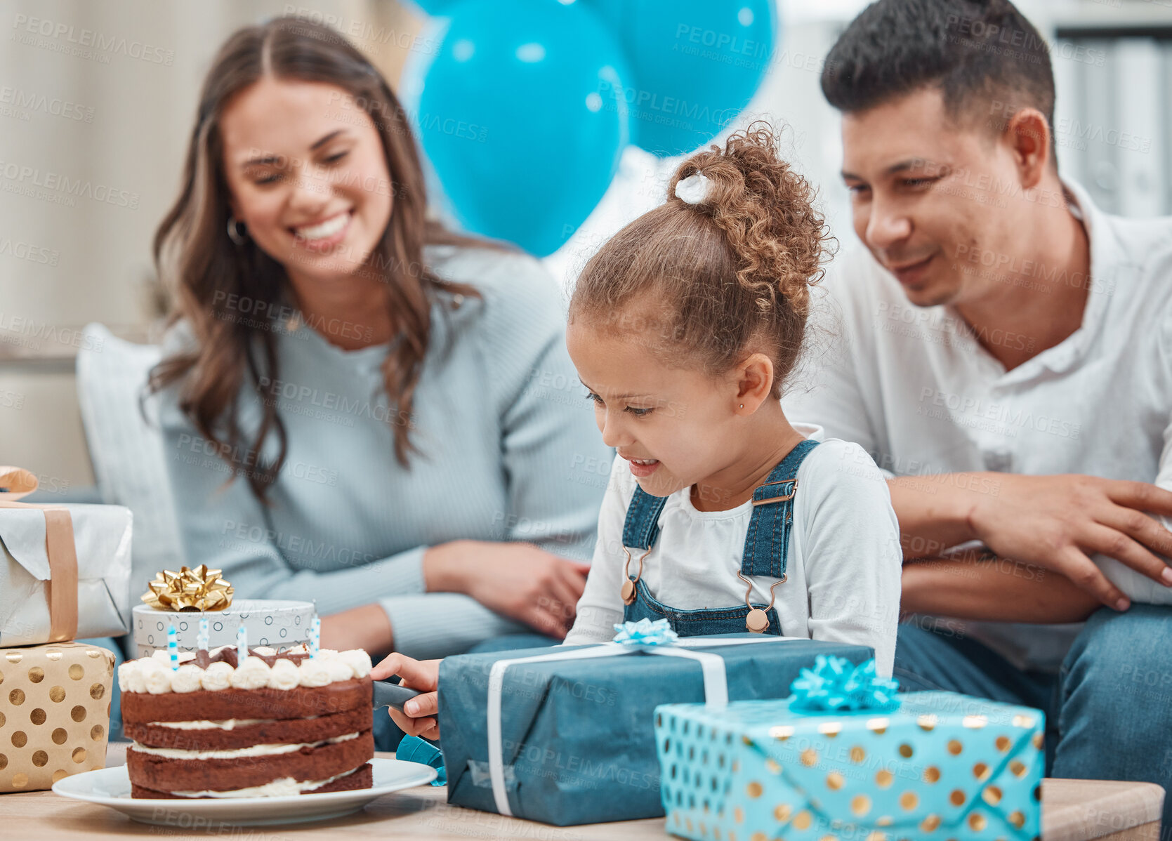 Buy stock photo Birthday, cake and cutting with family in living room for celebration, balloons and milestone event. Gift giving, love and support with people and party at home for growth, care and gathering.