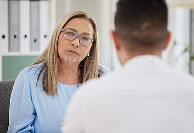 Buy stock photo Mature woman, psychiatrist and patient talking during consultation in the clinic or psychologist listen to a man at the office. Mental health, female therapist and conversation or guy for healing