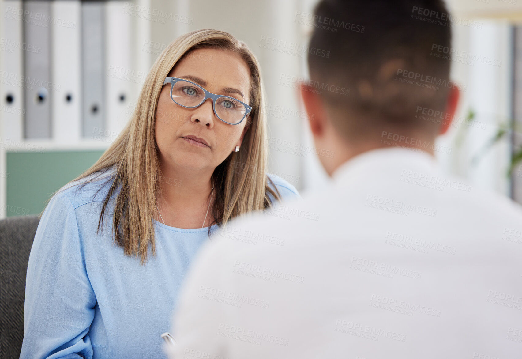 Buy stock photo Mature woman, psychiatrist and patient talking during consultation in the clinic or psychologist listen to a man at the office. Mental health, female therapist and conversation or guy for healing