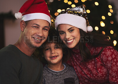 Buy stock photo Shot of a young family celebrating Christmas at home