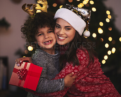 Buy stock photo Shot of a young mother and son exchanging Christmas gifts at home
