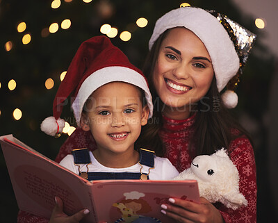 Buy stock photo Shot of a young mother and daughter reading a book during Christmas time at home