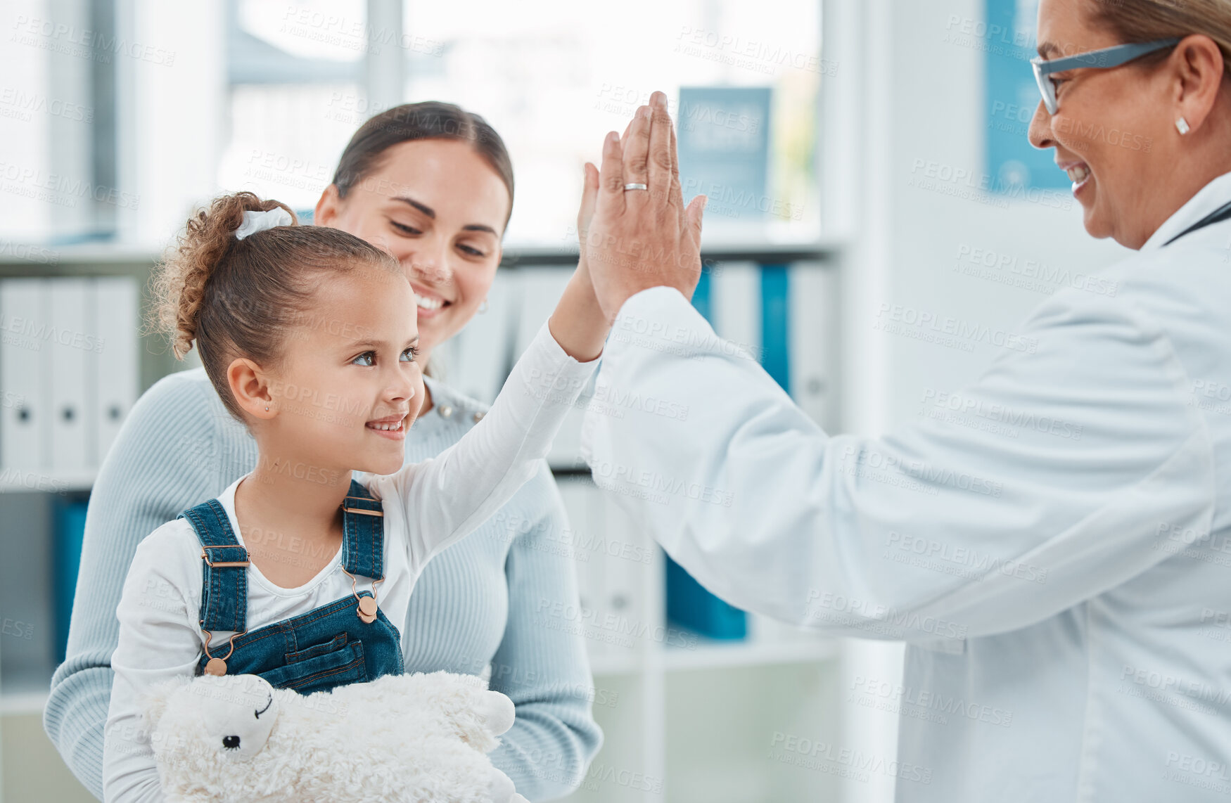 Buy stock photo High five, child and family doctor with mother, motivation and wellness assessment at pediatrician office. Mature professional, happy girl and medical clinic with smile and consultation success 