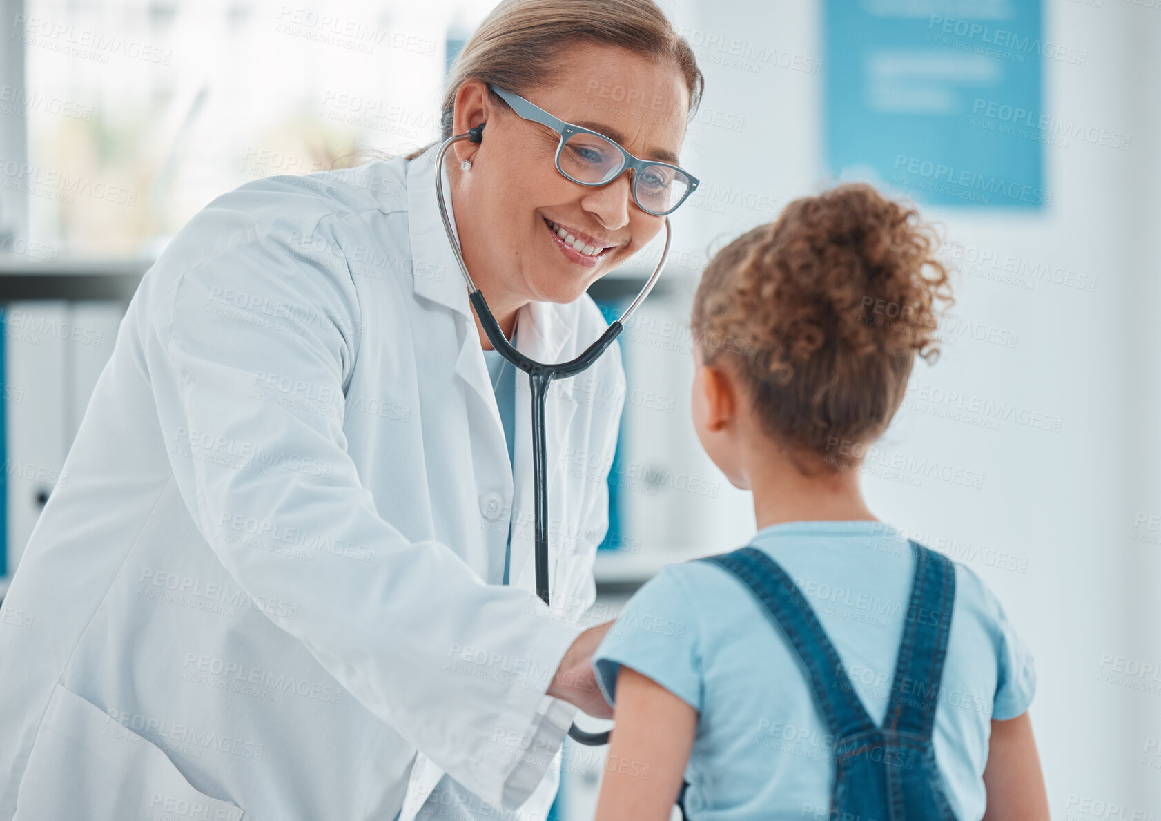 Buy stock photo Shot of a doctor examining a little girl with a stethoscope in a clinic
