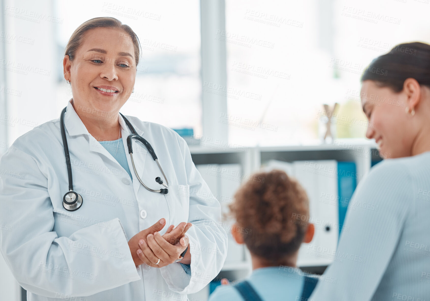 Buy stock photo Hospital, child and family doctor with mother, conversation and wellness assessment at pediatrician office. Mature professional, patient and healthcare clinic with smile and support for medical check