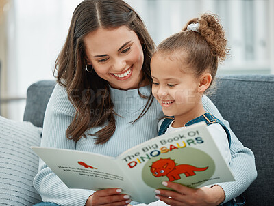 Buy stock photo Shot of a young mother reading to her daughter