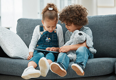 Buy stock photo Shot of a brother and sister playing together using their digital tablet
