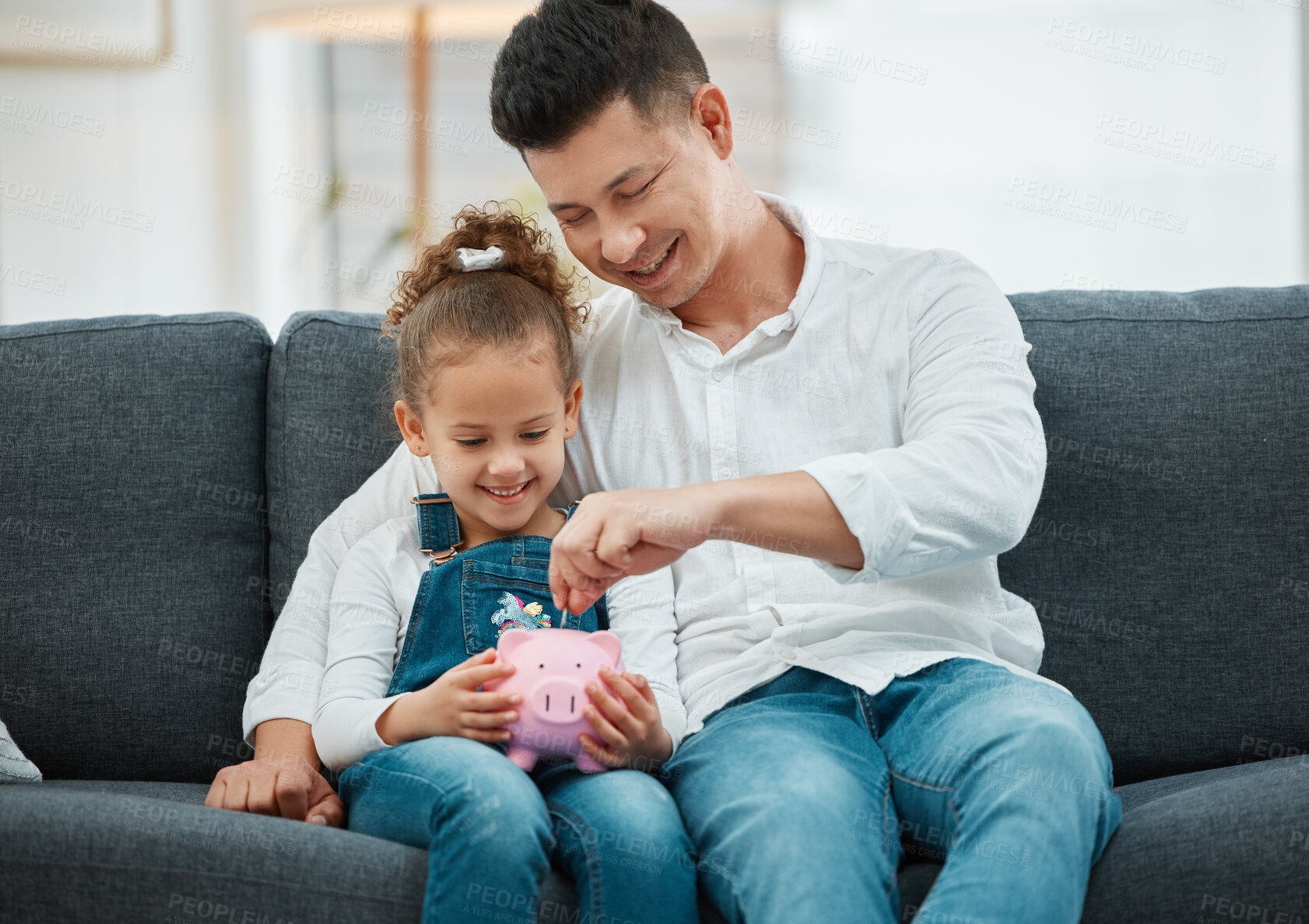 Buy stock photo Shot of a father teaching his daughter to save in a piggybank