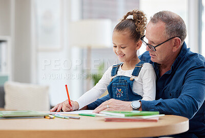 Buy stock photo Shot of a grandfather helping his grandchild with her homework at home